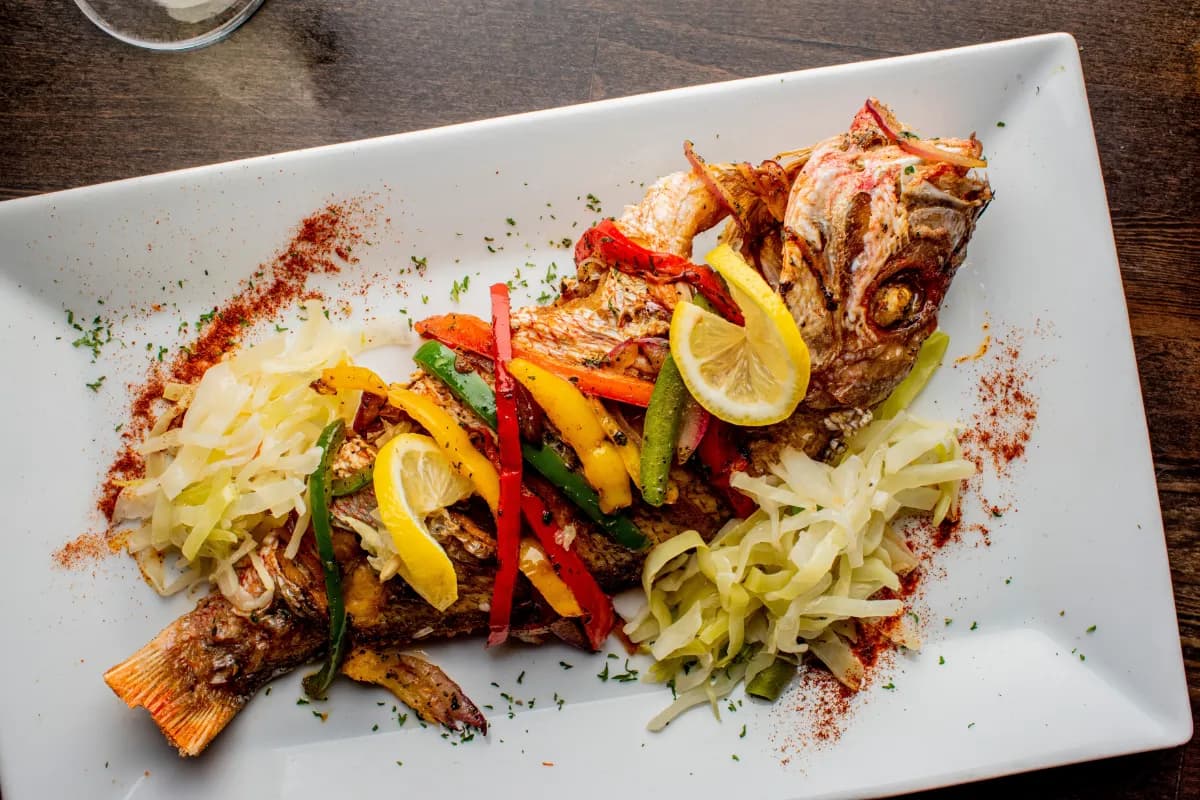 Red Snapper is a popular fish often grilled in coastal cuisines, including Seychelles, where it is marinated with local spices, lime, garlic, and herbs, then cooked over an open flame for a smoky, flavorful taste.