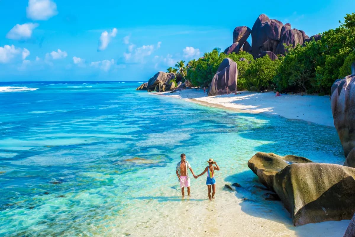 Anse Source d'Argent, La Digue Seychelles, a young couple of men and women on a tropical beach during a luxury vacation in Seychelles.
